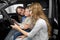 Mother observing new car with children in car cabin.