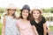 Mother outdoor nportrait with two girls daughter with straw hat near lake river in spring