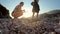 Mother playing with her baby kid on the beach in sunset lights