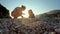 Mother playing with her baby kid on the beach in sunset lights