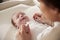 Mother Playing With Newborn Baby Lying On Changing Table