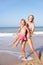 Mother playing with young girl on beach