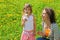 Mother plays with girl which breath on dandelion