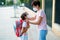 Mother preparing her little girl for the return to school wearing a mask.