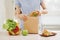 Mother preparing sandwich for school lunch on table