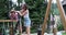 Mother pushing her daughter sitting on swing