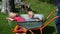 Mother pushing her Little son and daughter in a wheelbarrow