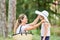 Mother puts daughter on a lady`s hat