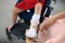 Mother puts on orthosis her daughter legs. Disabled girl sitting on a wheelchair. Child cerebral palsy