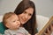 Mother reads a book to a baby daughter