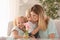 Mother receiving flowers from her cute little children at home