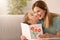 Mother receiving greeting card from her cute little daughter at home