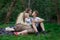 Mother resting with two children in nature. Family picnic in Park. Mom kisses son