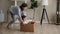 Mother riding daughter while she sit inside of carton box