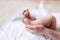 Mother`s hands carefully keeping baby`s foot with tenderness