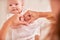 Mother`s hands holding baby`s hands. folded symbol of heart and love from fingers. motherhood and care for the baby