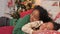 Mother and schoolgirl hug on bed in Christmas atmosphere