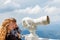 Mother shows son landscapes in valley of Rhodope Mountains and sky through telescope on observation tower of Snezhan