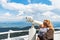 Mother shows son landscapes in valley of Rhodope Mountains and sky through telescope on observation tower of Snezhan