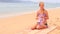 mother shows swimsuit to daughter sitting on sandy beach