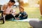 Mother sitting in park with her kids