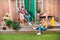 Mother sitting in rocking chair and smiling daughter cultivating plant on porch