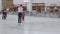 Mother skates with girl on ice arena in shopping mall