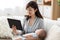 Mother with sleeping baby and tablet pc at home