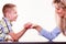 Mother and son arm wrestle sit at table.