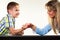 Mother and son arm wrestling.