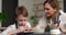 Mother and son boy adorn a clay bowl with letters together. Master class in a pottery workshop. Slow motion