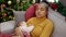 Mother and son celebrating christmas sleeping on sofa while breastfeeding baby at home