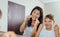 Mother and son cleaning teeth with dental floss