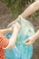 Mother and son collecting plastic bottles. Family carry garbage bag. Plastic pollution on land