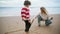 Mother son drawing beach with sticks on autumn weekend. Family playing seaside