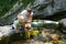 Mother with son drinking water from a pure, fresh and cool mountain stream on a family trip