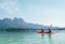 Mother and son floating on kayak together on Cheow Lan lake in Thailand