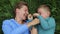 Mother and son fooling around lying on the grass. Laughing, having fun