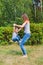 Mother and son have fun playing in park. Littkek kid making steps upwards over moms legs