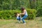 Mother and son have fun playing in park. Littkek kid making steps upwards over moms legs