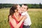 Mother and son hugging in field. Happy mother embracing her son in park. Mother hugging her child. Motherhood. Young mother cuddle