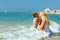 Mother and son kiss in sea water on beach