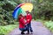 Mother and son laughing under a colorful umbrella