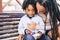 Mother and son love - childhood family concept with black race kid and mommy with dreads together hug and have fun at the park -