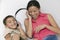 Mother and Son lying on sofa Sharing Headphones