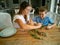 Mother and son make round frame from twigs