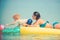 Mother with son play ball in water. Happy family on Caribbean sea. Pineapple inflatable or air mattress. Summer vacation