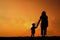 A mother and son playing outdoors at sunset silhouette