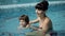 Mother and son in the pool. Young mother teaches her 3-year-old son to swim