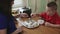 Mother and son putting chocolate on the top of a cake.